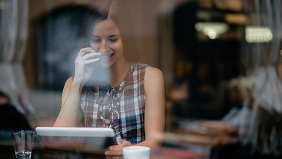 woman-siting-while-looking-at-tablet