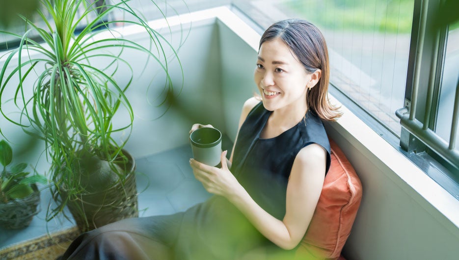 観葉植物に囲まれてリラックスする女性