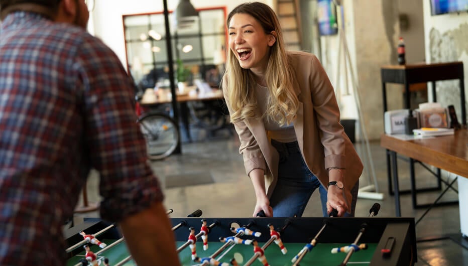 woman laughing and playing table football